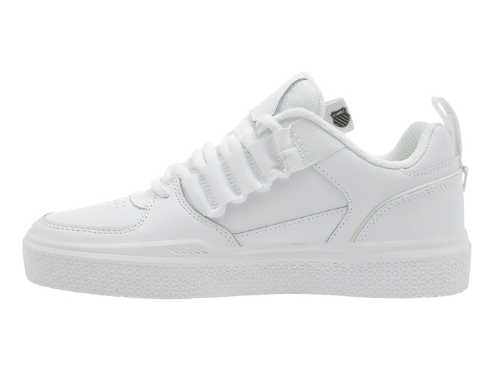 Tenis K-Swiss color blanco con agujetas y correa de velcro superior, suela blanca texturizada.