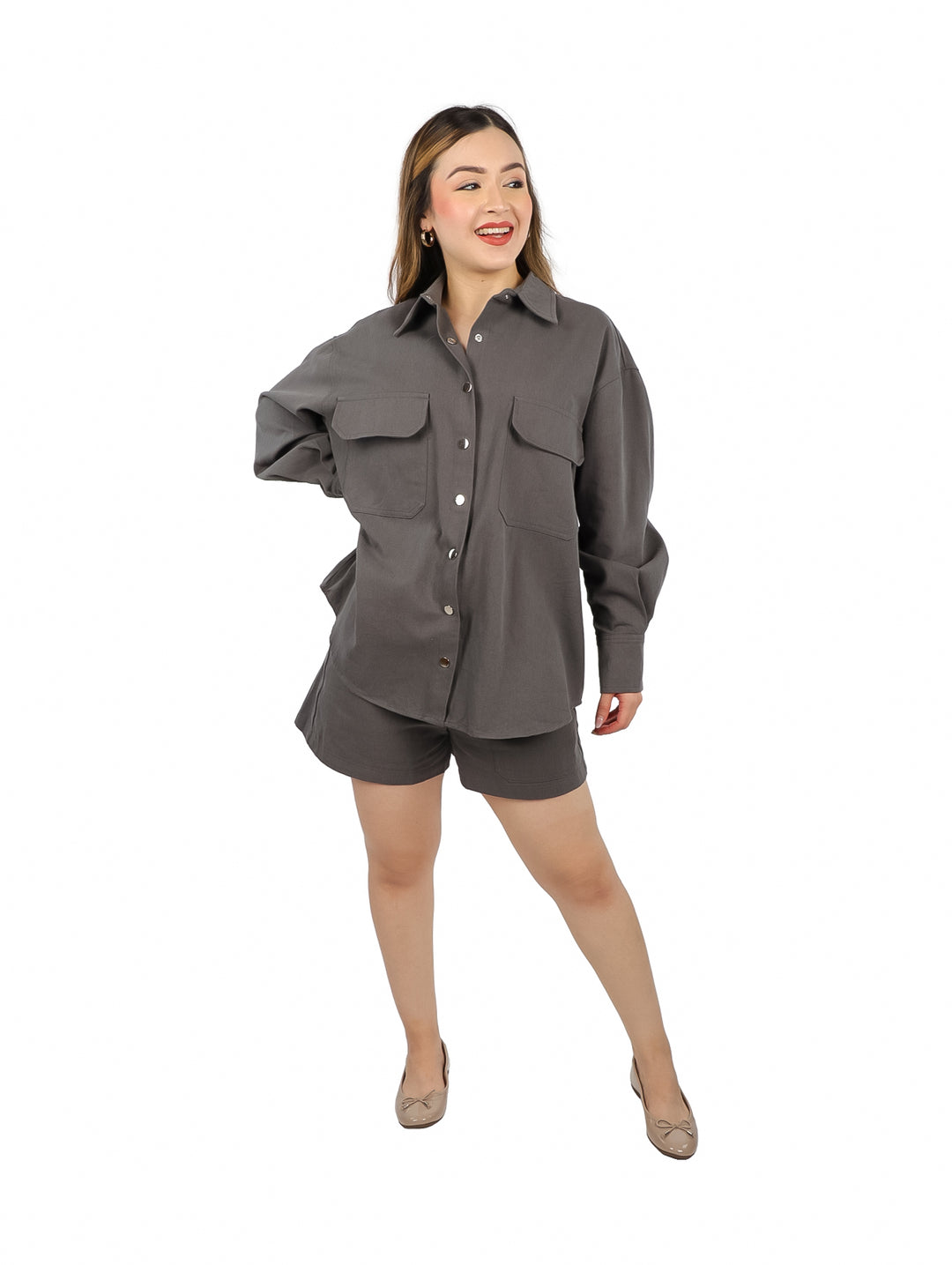 Mujer vistiendo un conjunto casual de color gris compuesto por una camisa de manga larga y un short.