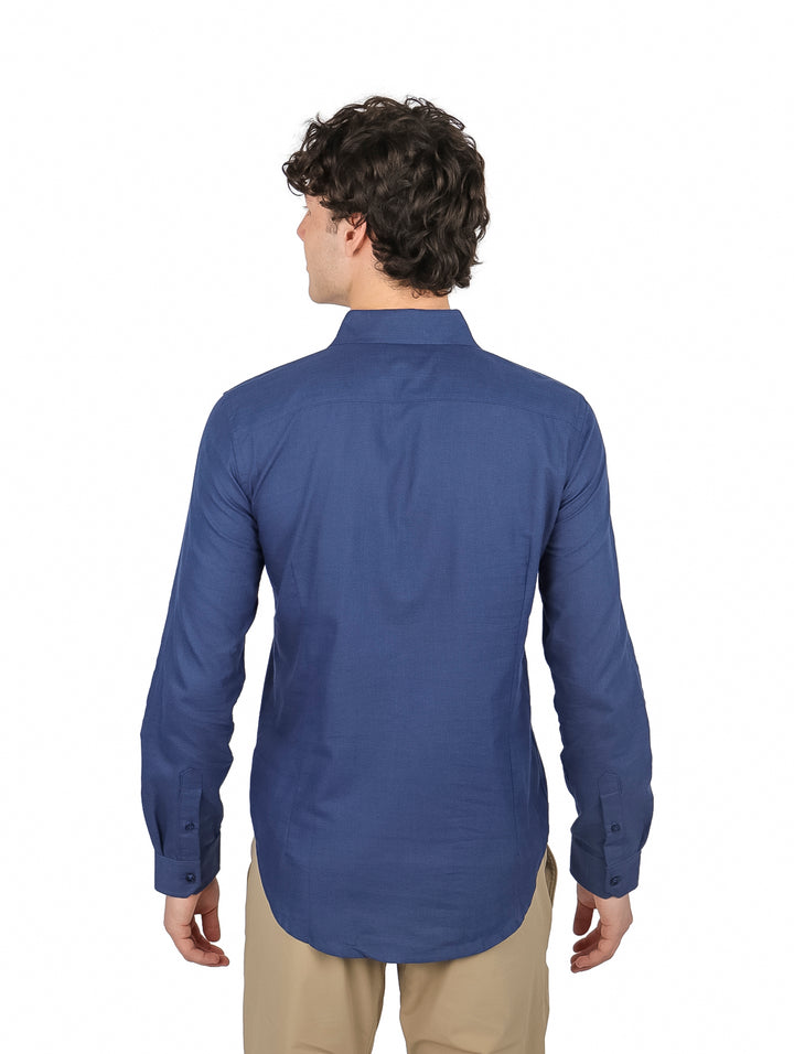 Hombre vistiendo una camisa de manga larga color azul marino y pantalones beige.