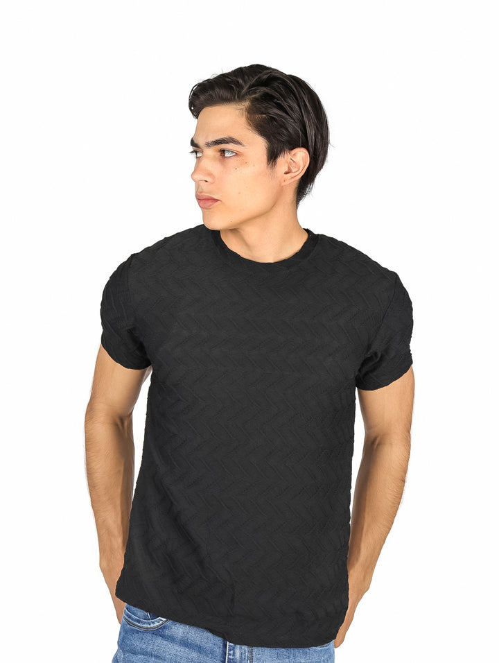 Hombre vistiendo playera negra de manga corta con textura geométrica sutil y cuello redondo.