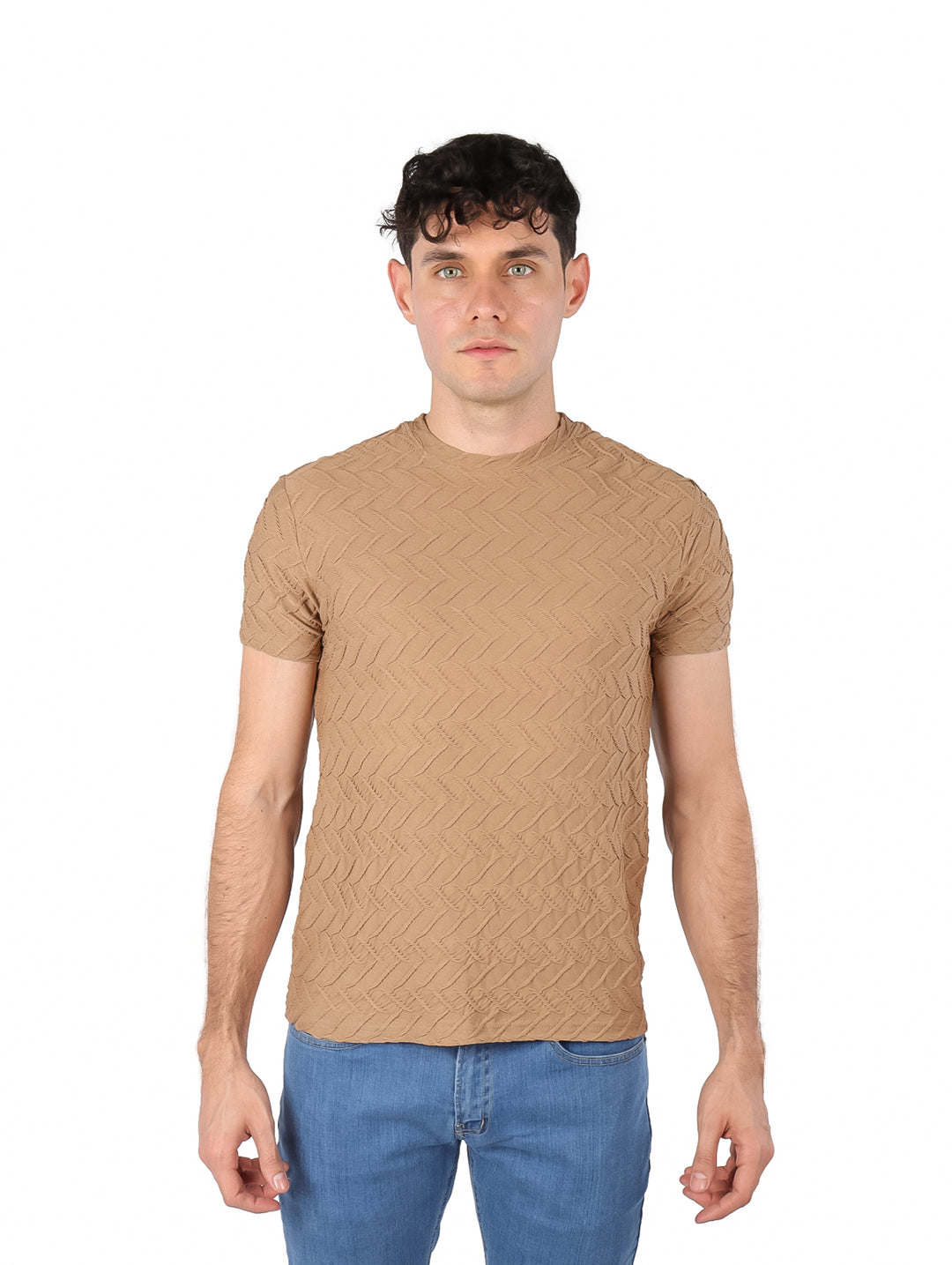 Hombre vistiendo playera de manga corta color marrón con textura geométrica en relieve y jeans azules.