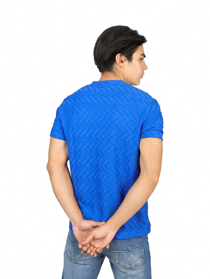Hombre vistiendo playera azul royal de manga corta con textura geométrica en relieve y cuello redondo.