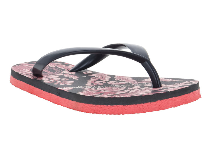 Sandalias negras con estampado floral y suela de color rojo intenso.