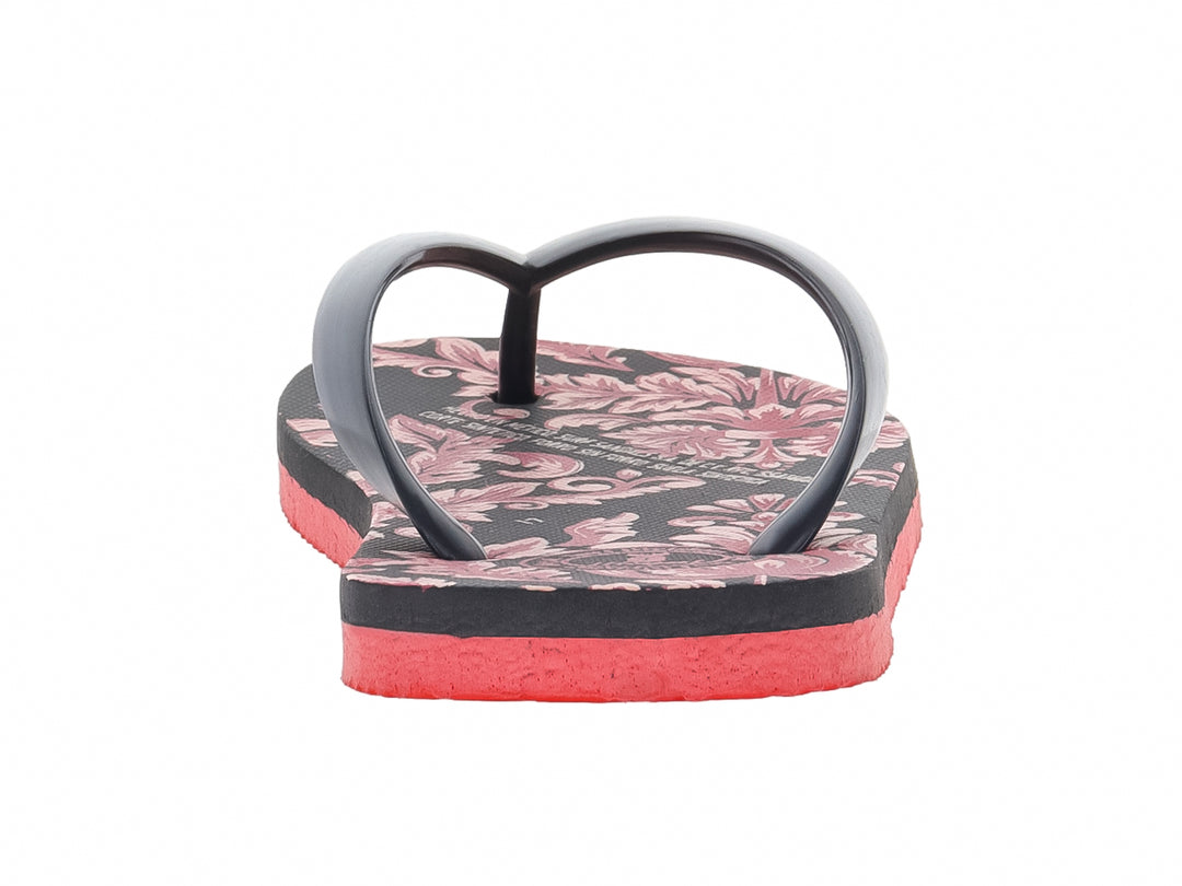 Sandalias negras con estampado floral y suela de color rojo intenso.