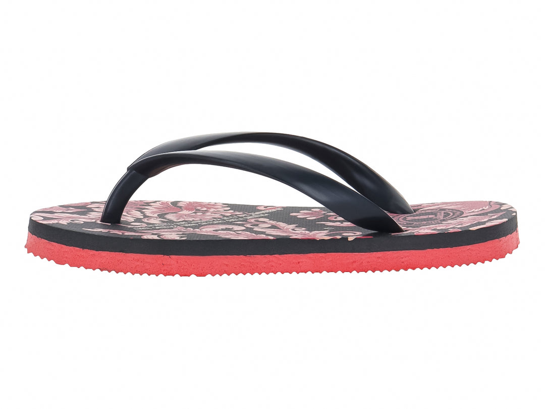 Sandalias negras con estampado floral y suela de color rojo intenso.