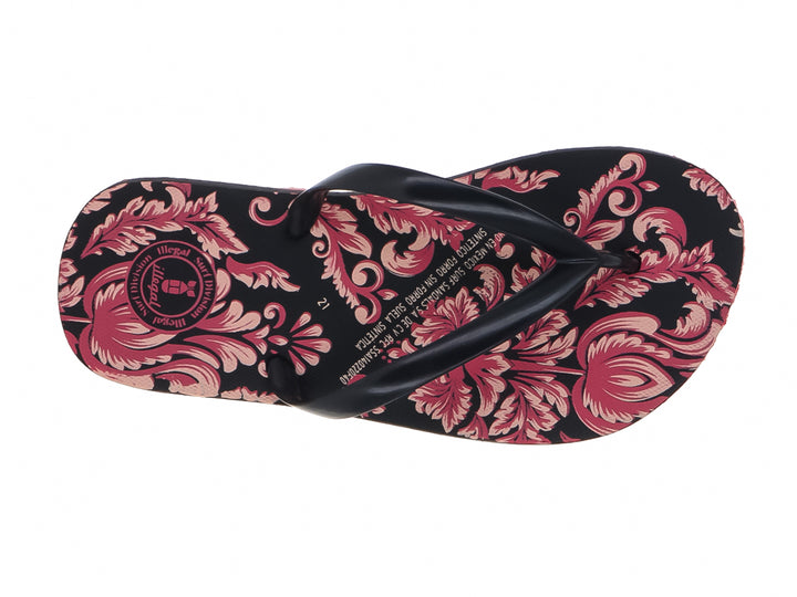 Sandalias negras con estampado floral y suela de color rojo intenso.