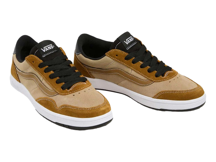 Tenis VANS color marrón bronce con detalles en beige, cordones negros y suela blanca.