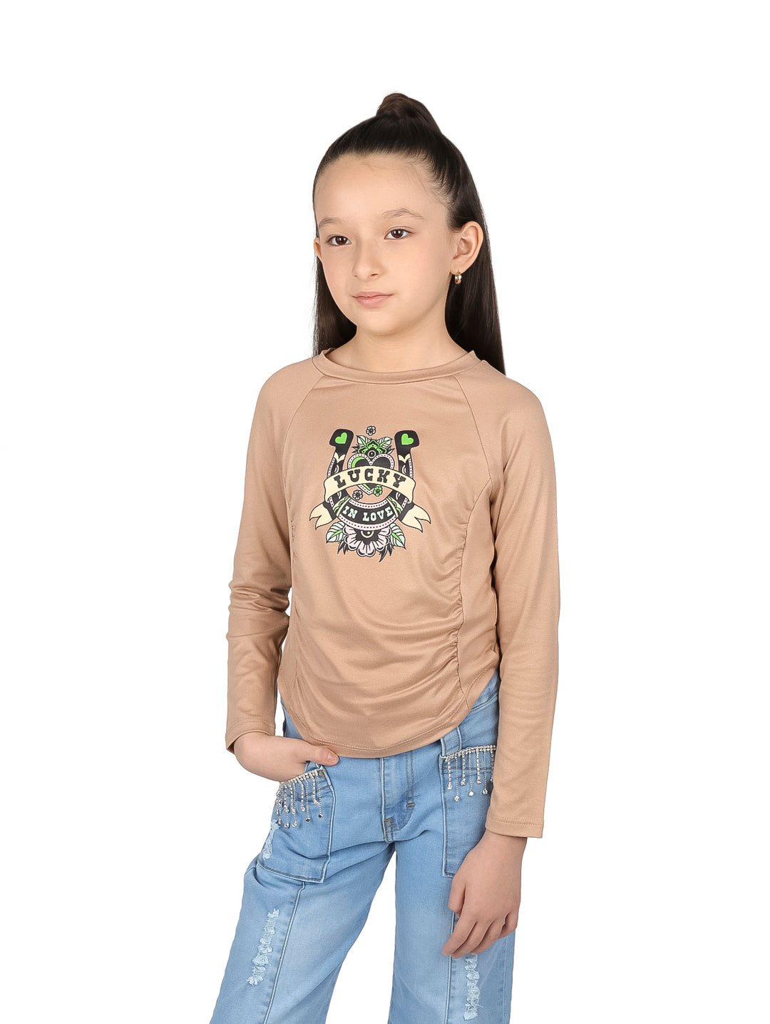 Niña vistiendo blusa color khaki de manga larga con estampado frontal y detalle corrugado.