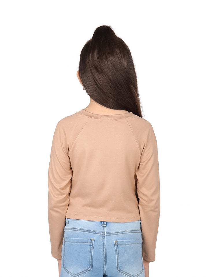 Niña vistiendo blusa color khaki de manga larga con estampado frontal y detalle corrugado.