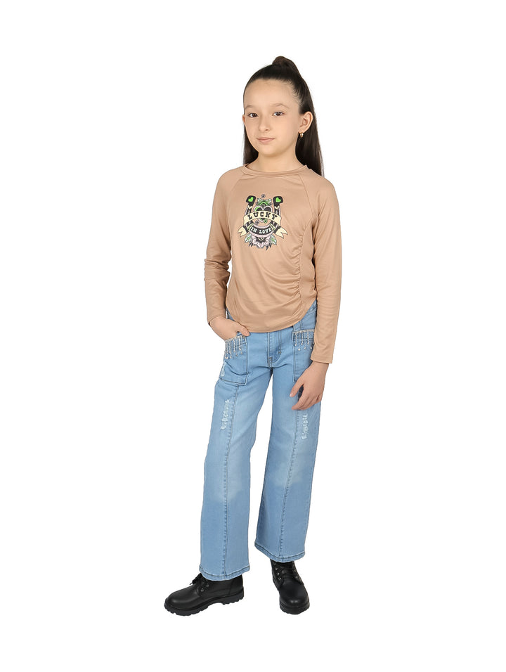 Niña vistiendo blusa color khaki de manga larga con estampado frontal y detalle corrugado.