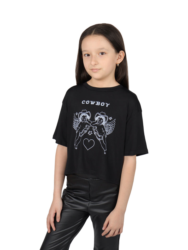 Niña vistiendo una blusa negra de manga corta con estampado blanco de ángeles vaqueros y la palabra COWBOY.