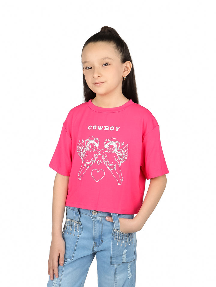 Niña vistiendo blusa rosa de manga corta con estampado de ángeles cowboy y texto COWBOY.