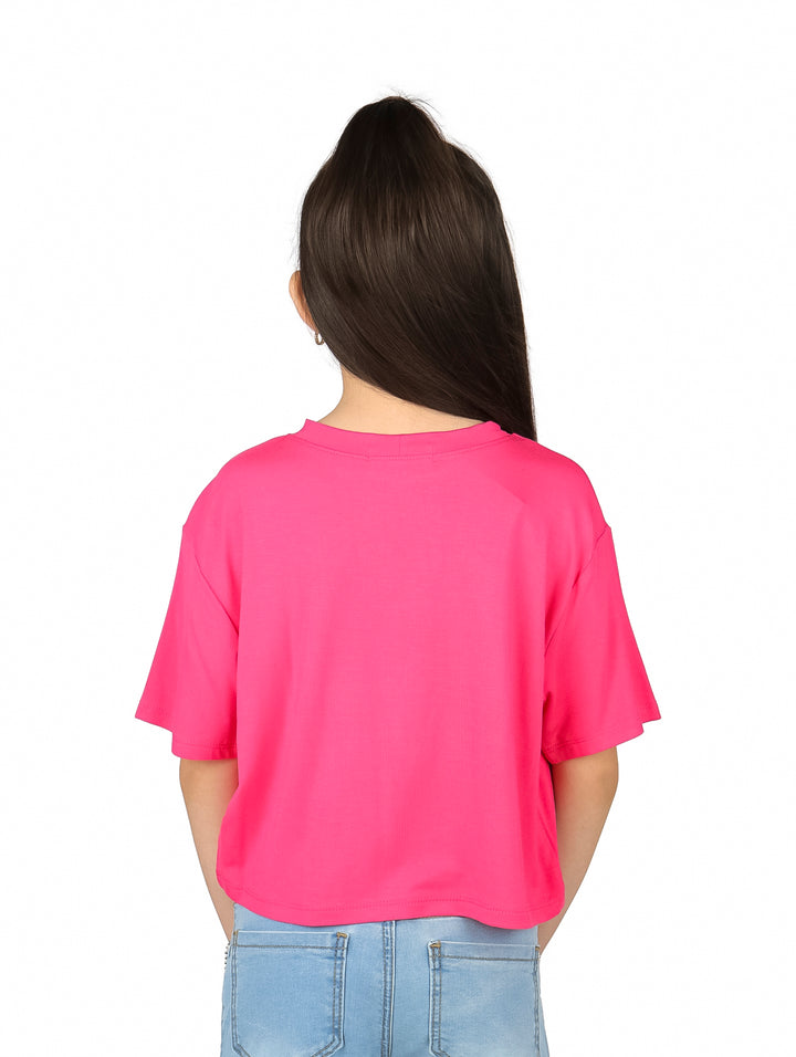 Niña vistiendo blusa rosa de manga corta con estampado de ángeles cowboy y texto COWBOY.
