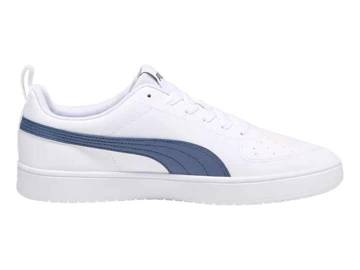 Tenis PUMA Rickie en color blanco con franja lateral en azul marino y suela blanca.