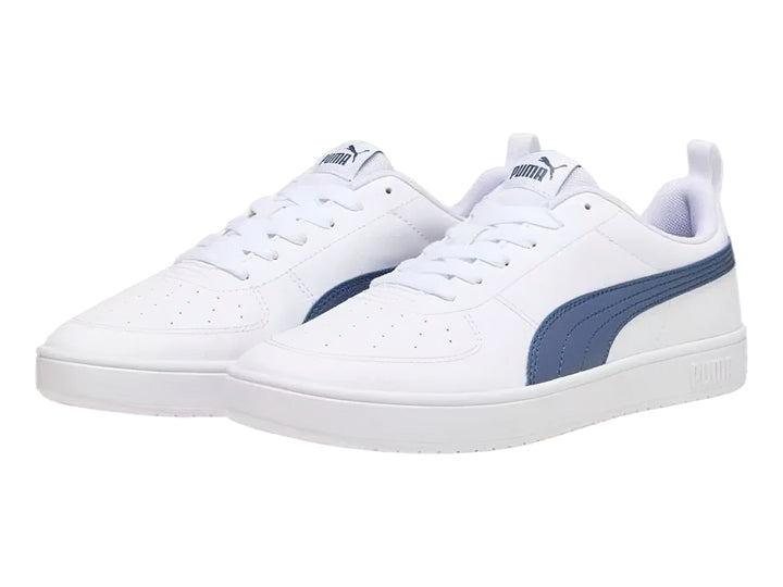 Tenis PUMA Rickie en color blanco con franja lateral en azul marino y suela blanca.