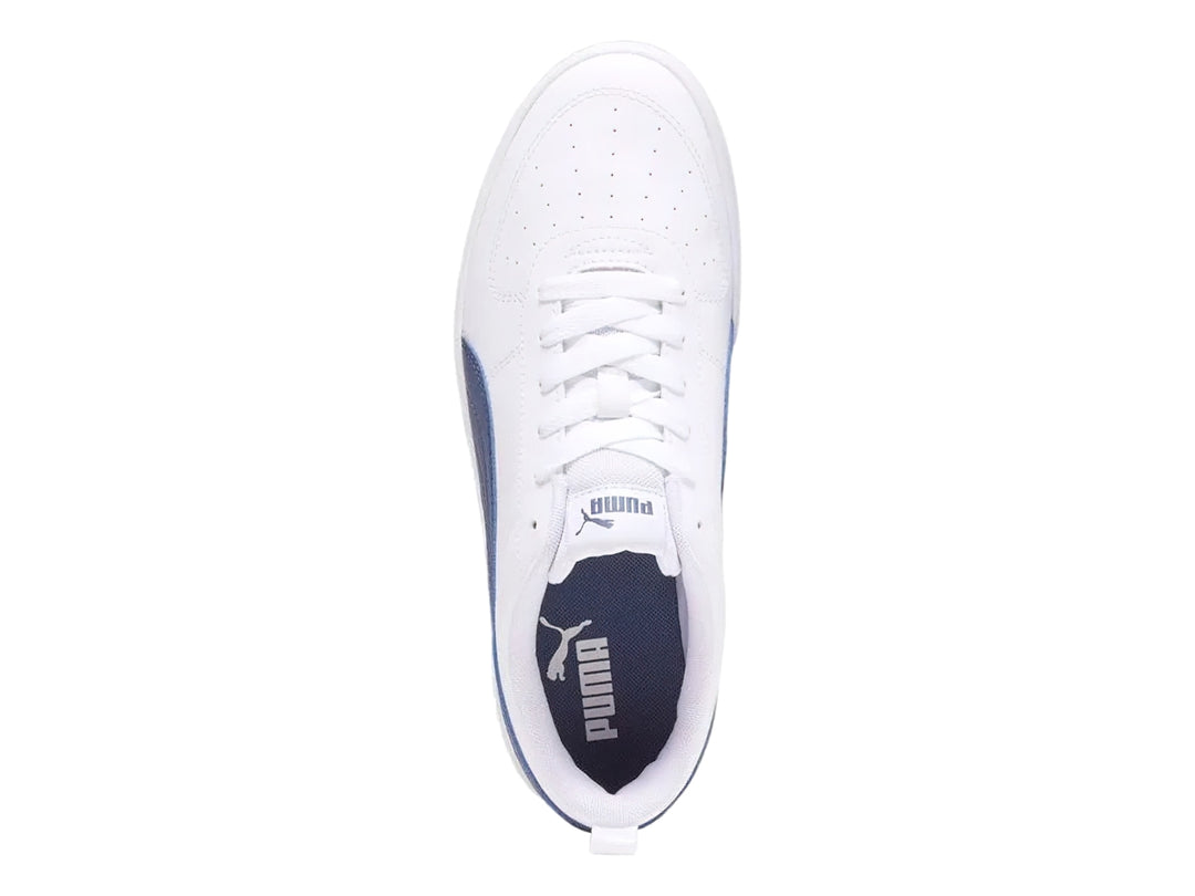 Tenis PUMA Rickie en color blanco con franja lateral en azul marino y suela blanca.