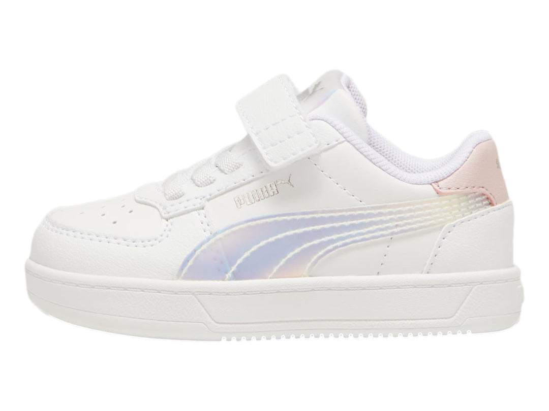 Tenis PUMA blancos para niños con detalles en rosa y plateado holográfico, cierre de agujetas y correa de velcro.