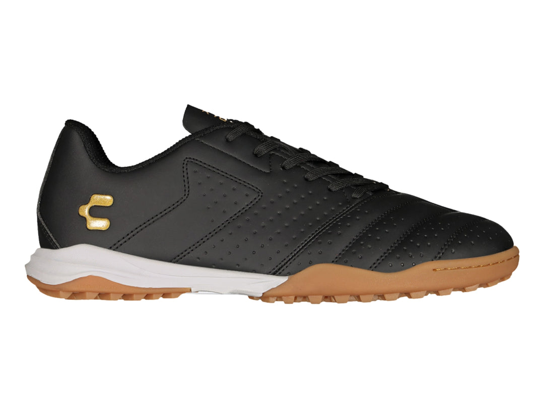 Zapato de fútbol Charly en color negro con suela blanca y marrón y logotipo dorado.