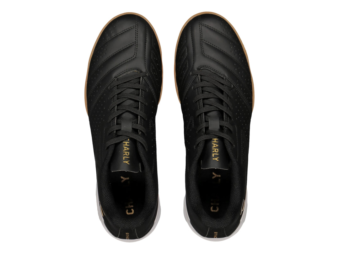 Zapato de fútbol Charly en color negro con suela blanca y marrón y logotipo dorado.