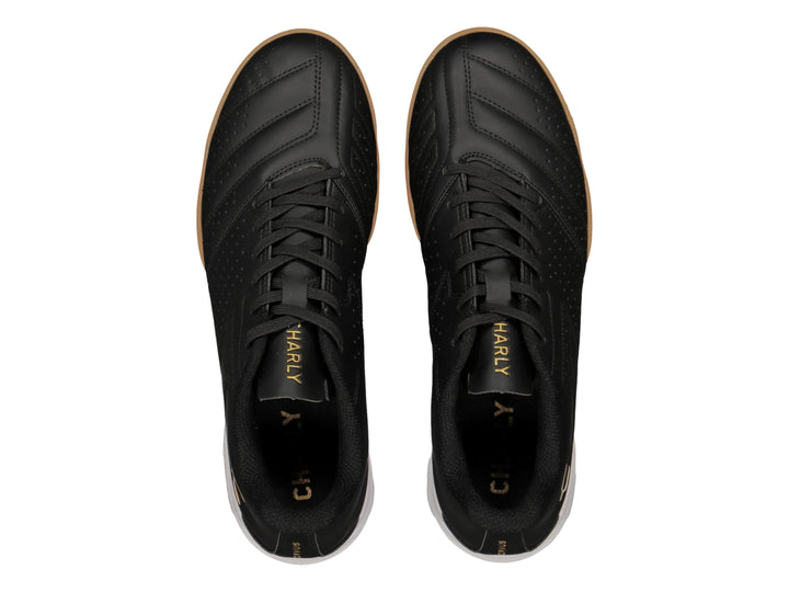 Zapato de fútbol Charly en color negro con suela blanca y marrón y logotipo dorado.