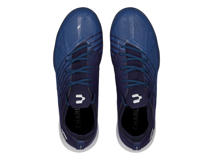 Calzado de fútbol Charly color azul marino con suela blanca y azul, diseño sintético para canchas artificiales.