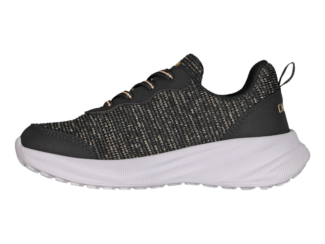 Tenis deportivos Charly en color negro con detalles dorados y suela blanca gruesa.