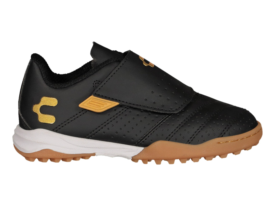 Zapato de fútbol Charly negro con detalles dorados y cierre de velcro.