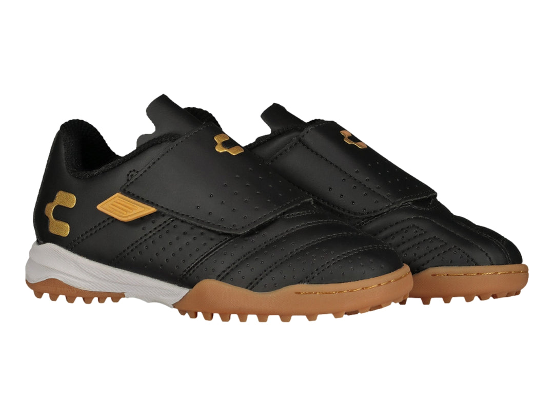 Zapato de fútbol Charly negro con detalles dorados y cierre de velcro.