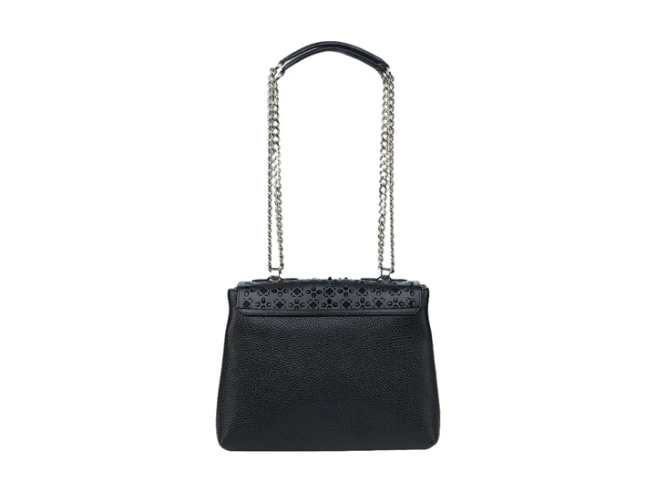 Bolso de cuero negro con correa de cadena plateada y detalles perforados en la solapa.