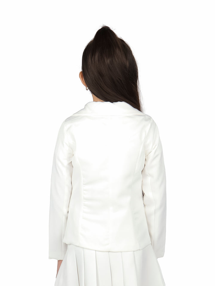 Conjunto de ropa para niña en color ivory, compuesto por una chaqueta con estampado de muñeca y falda plisada.