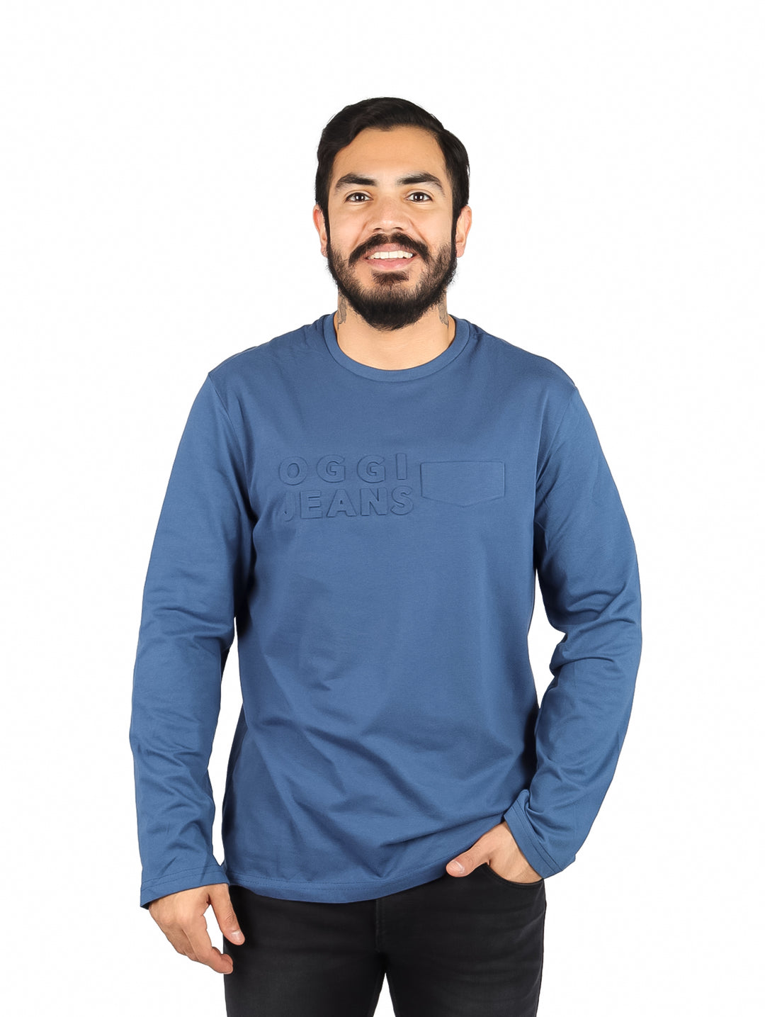 Hombre usando una playera de manga larga color petroleo con logotipo OGGI Jeans en el pecho.