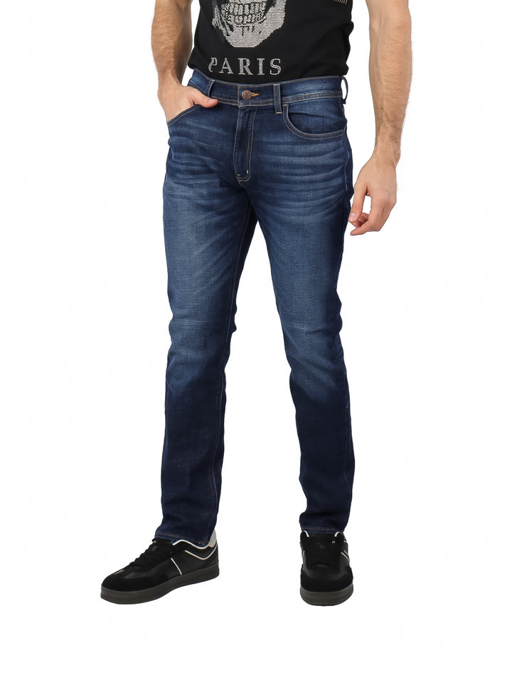 Hombre vistiendo pantalones de mezclilla azul oscuro con efecto lavado stone wash.