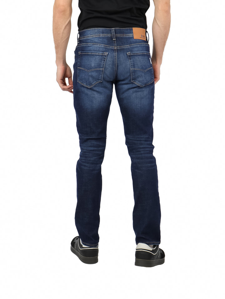 Hombre vistiendo pantalones de mezclilla azul oscuro con efecto lavado stone wash.