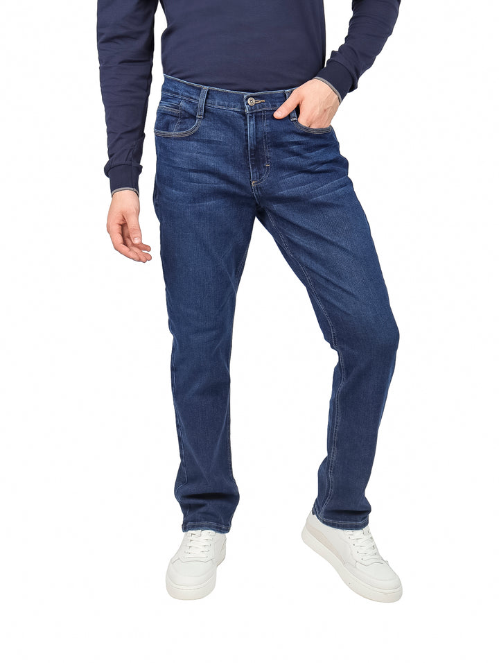 Hombre vistiendo pantalones LEE 112 slim fit en color azul stone con calzado blanco.