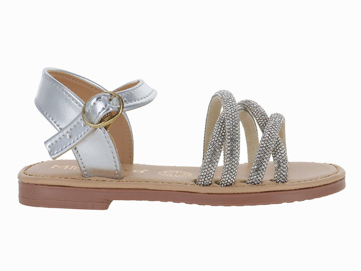 Sandalia plana para niña en color plata metalizado con tiras brillantes y hebilla ajustable.