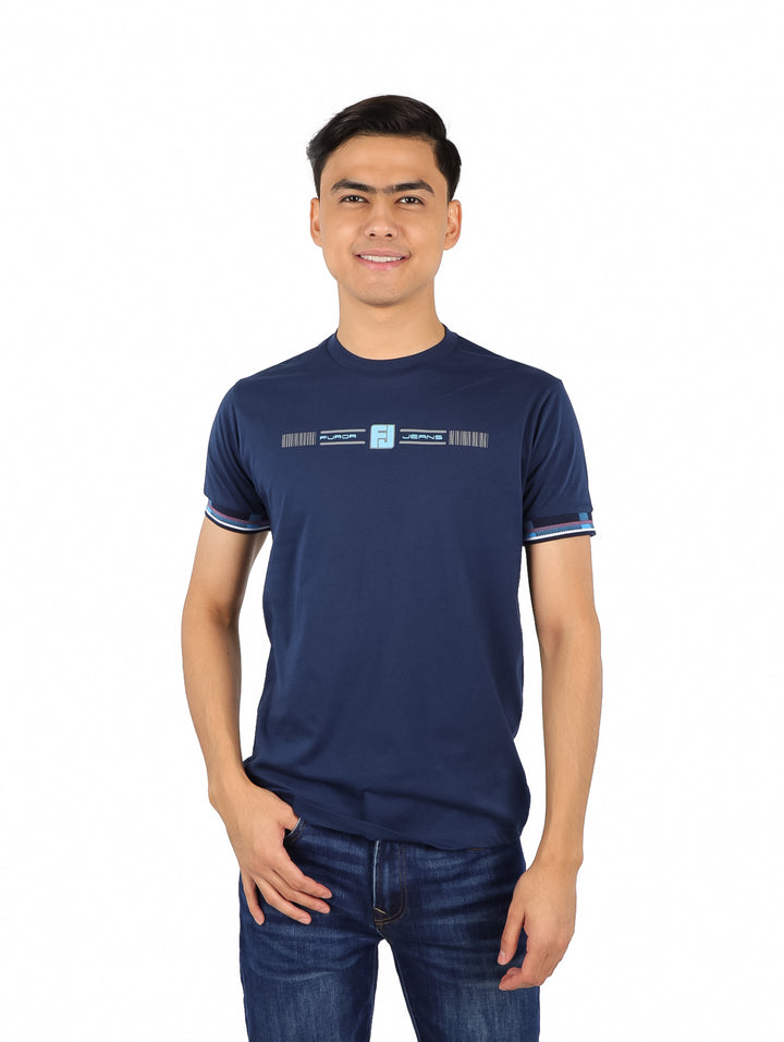 Hombre vistiendo playera azul marino con estampado en el pecho y detalles de rayas en las mangas.