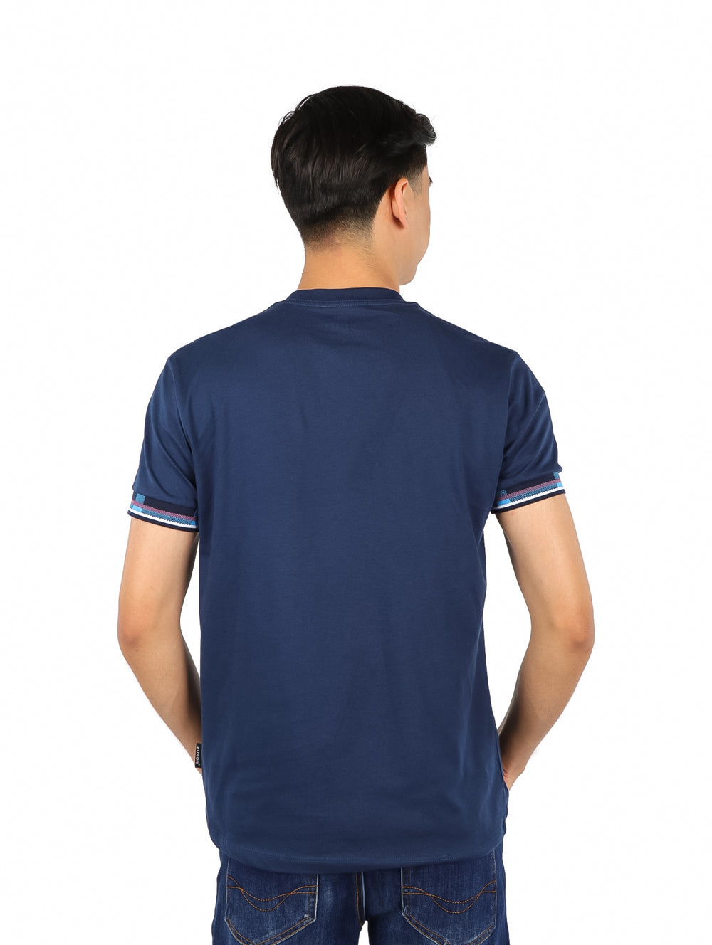 Hombre vistiendo playera azul marino con estampado en el pecho y detalles de rayas en las mangas.