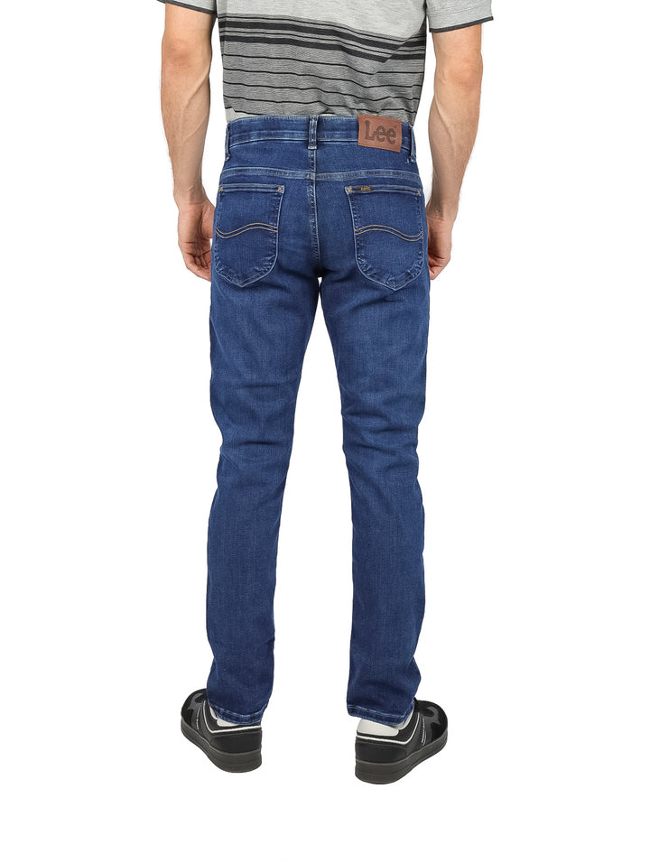 Hombre vistiendo pantalones LEE slim fit en color azul oscuro.