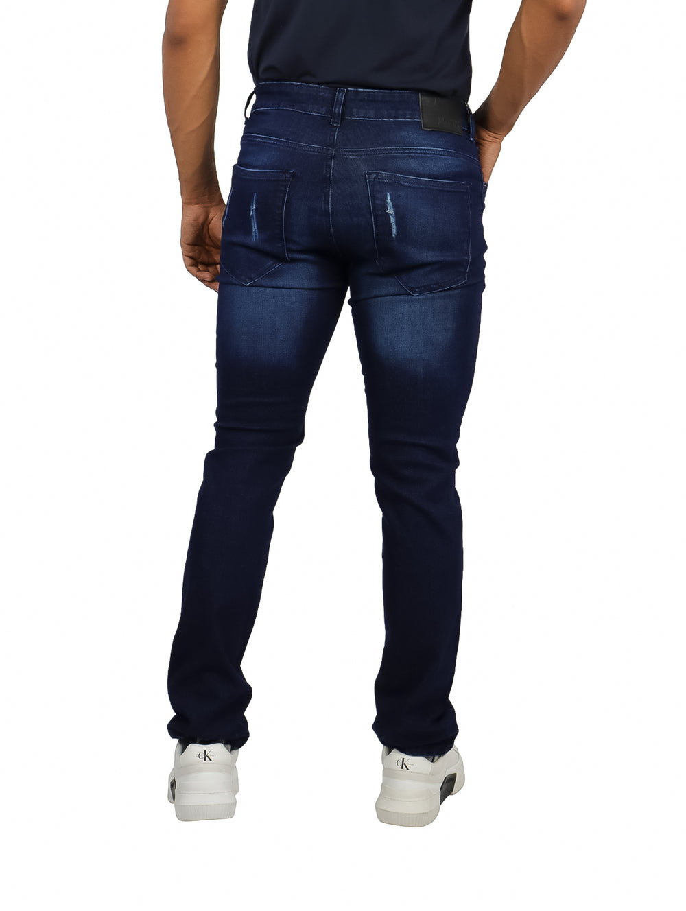 Pantalones jeans de mezclilla azul oscuro con efecto stone wash.