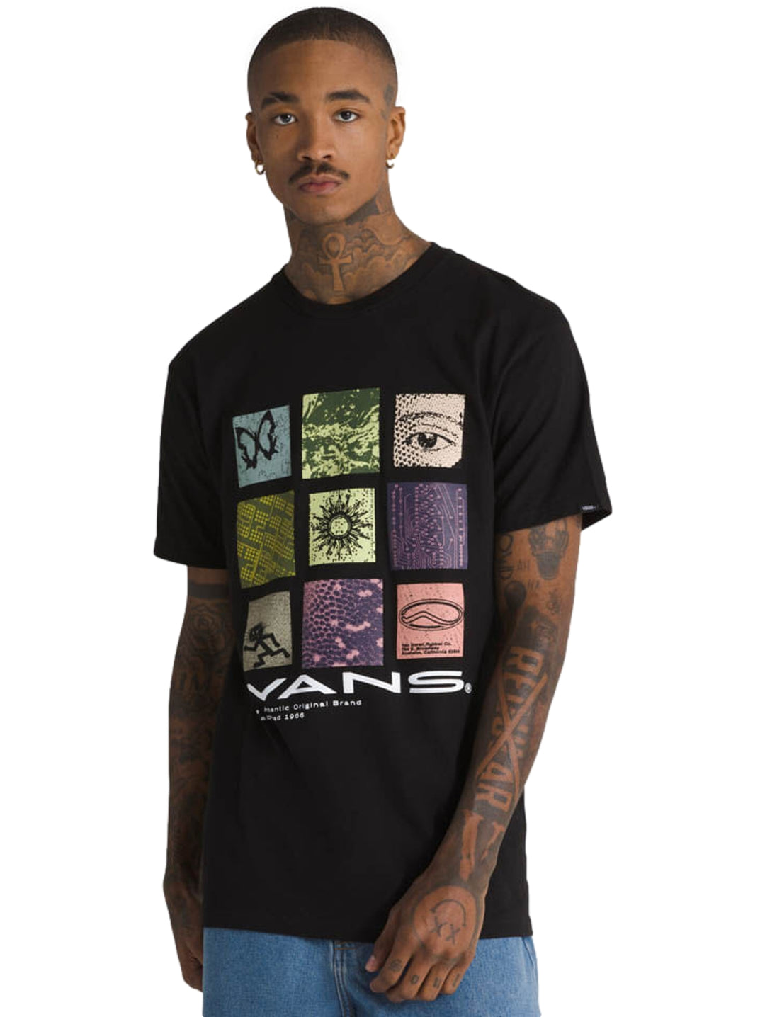 Hombre vistiendo una camiseta negra de manga corta VANS con un estampado gráfico colorido en el pecho.
