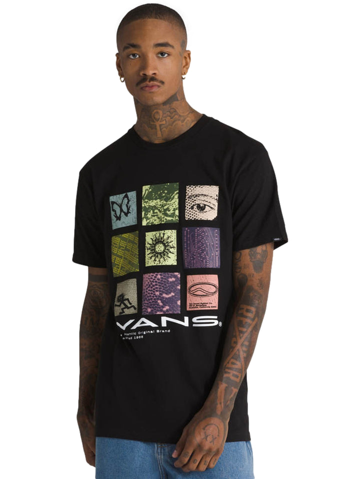Hombre vistiendo una camiseta negra de manga corta VANS con un estampado gráfico colorido en el pecho.