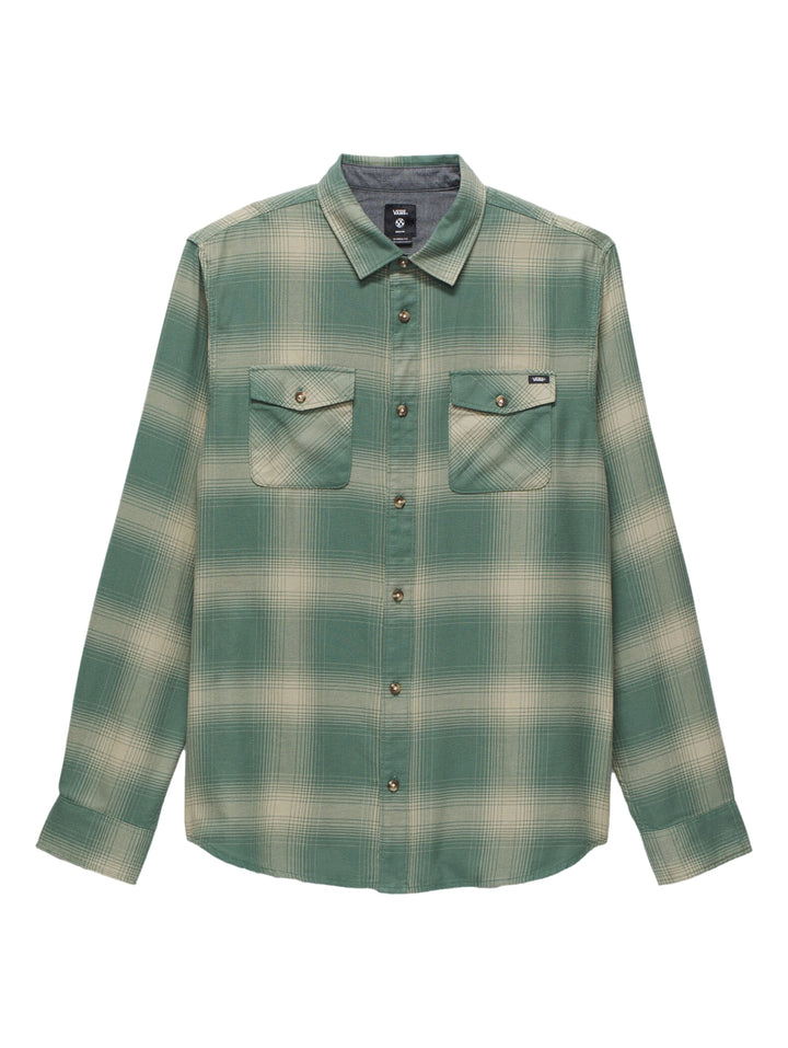 Hombre vistiendo camisa VANS de manga larga con estampado de cuadros en colores verde bosque y beige.