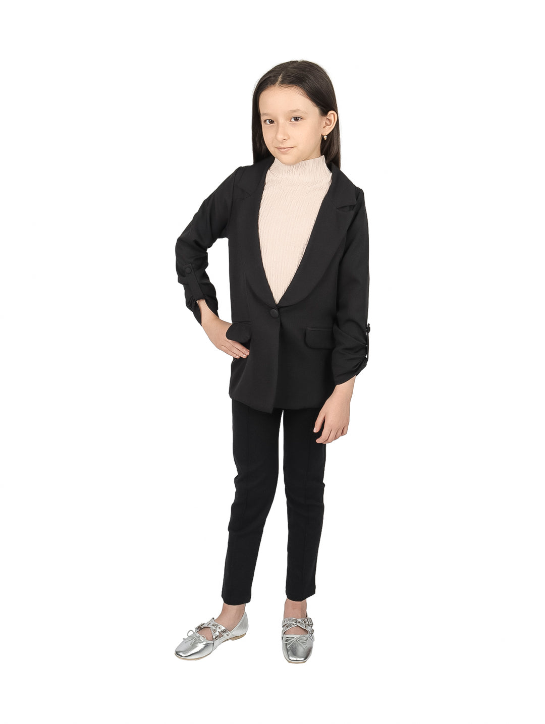 Niña vistiendo un saco negro elegante sobre un suéter beige.