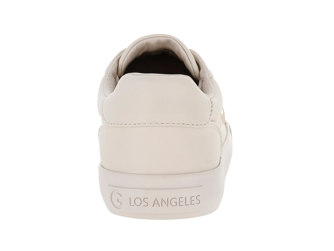 Tenis casuales color ivory con cordones blancos y detalle metálico lateral en forma de G.