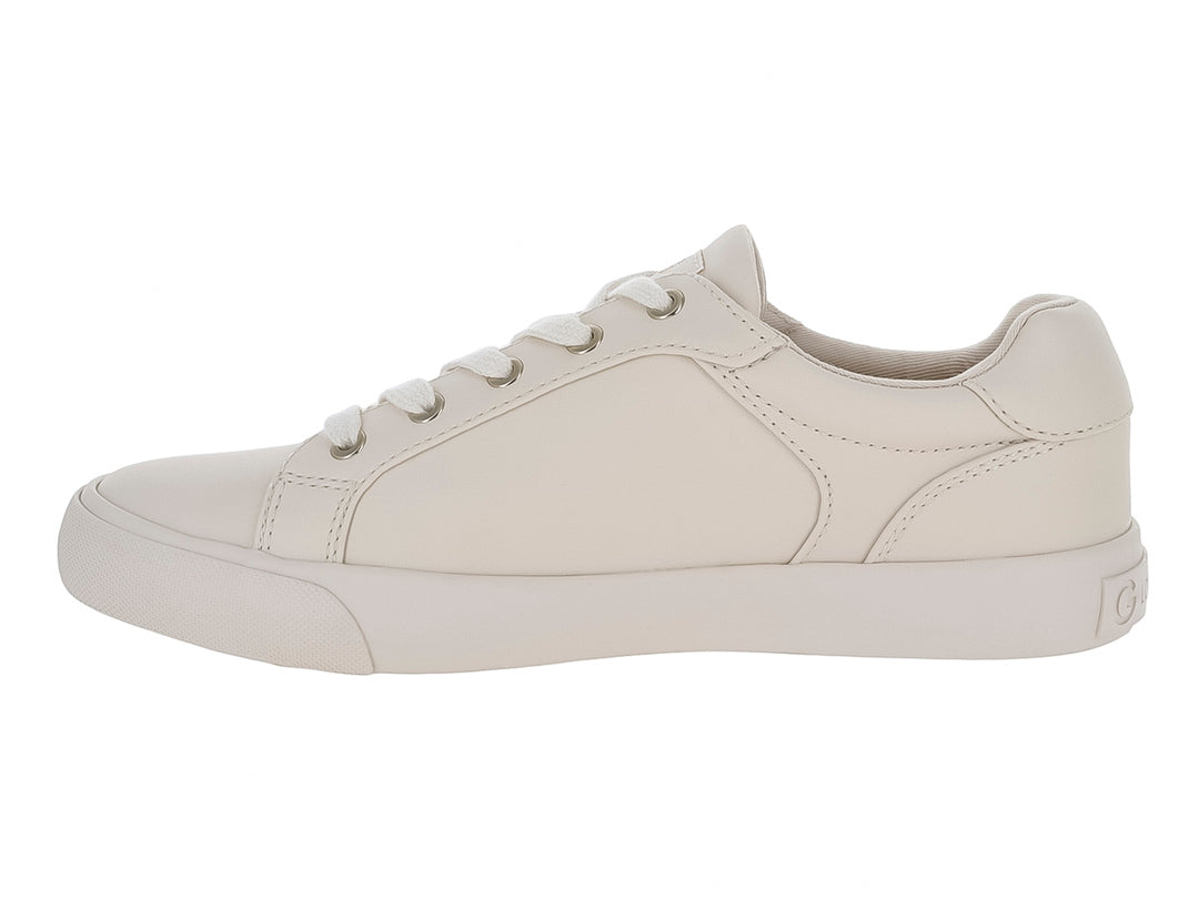Tenis casuales color ivory con cordones blancos y detalle metálico lateral en forma de G.