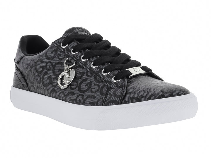 Tenis casuales negros con estampado de letras G, suela blanca y un dije metálico en las agujetas.