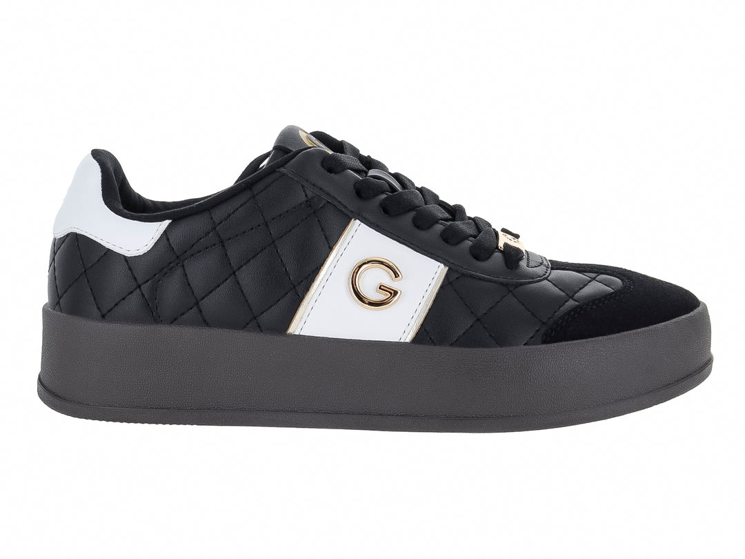 Tenis negros de plataforma con diseño acolchado en diamante y detalles laterales en color blanco.