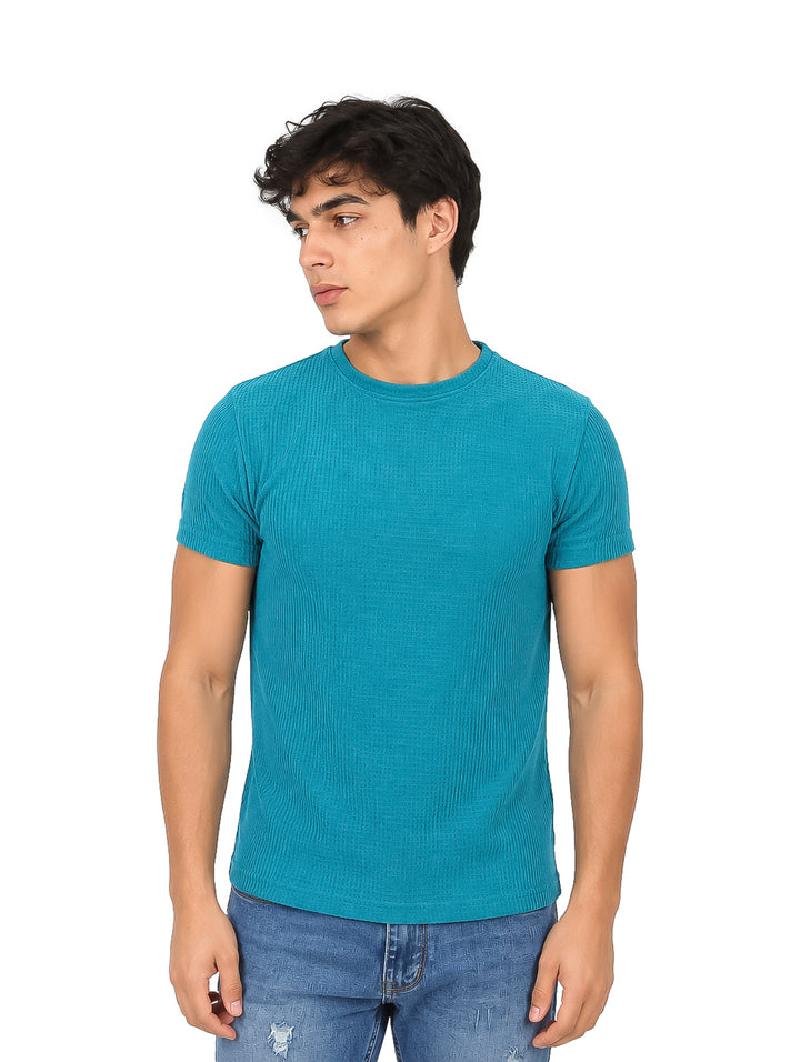 Hombre vistiendo una playera azul de manga corta con textura y cuello redondo.