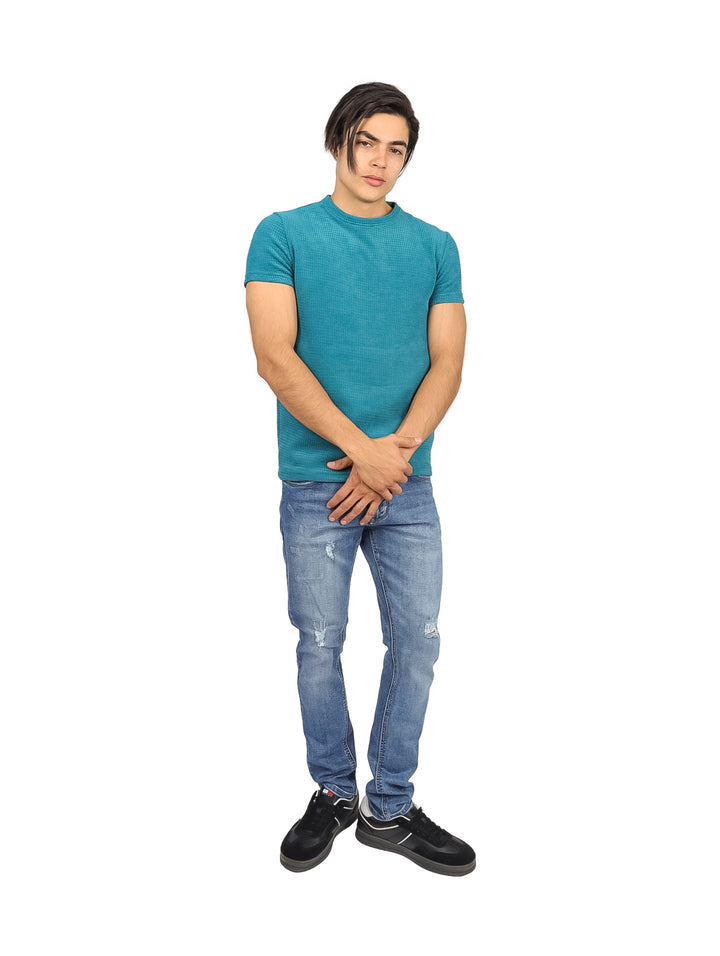 Hombre vistiendo una playera azul de manga corta con textura y cuello redondo.