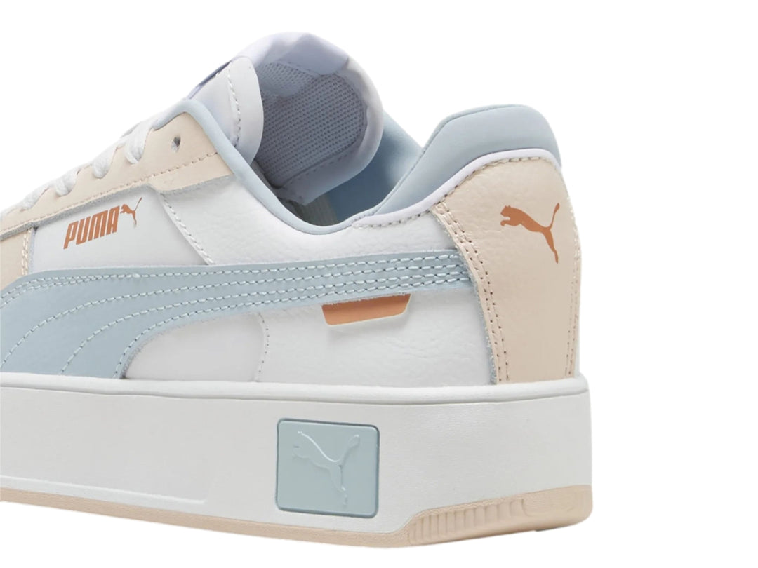 Tenis PUMA Carina Street PS en color blanco con detalles en azul claro y rosa pálido, con suela de plataforma blanca.